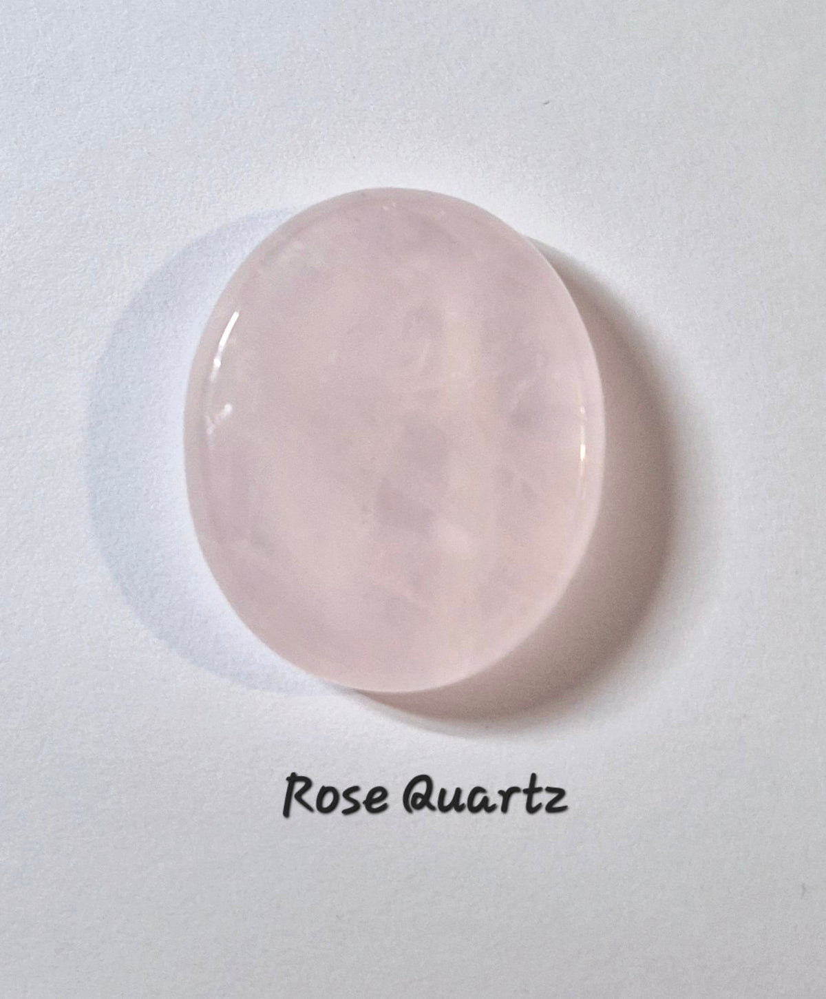 A smooth, polished oval rose quartz stone on a white background with the text 'Rose Quartz' written below it.