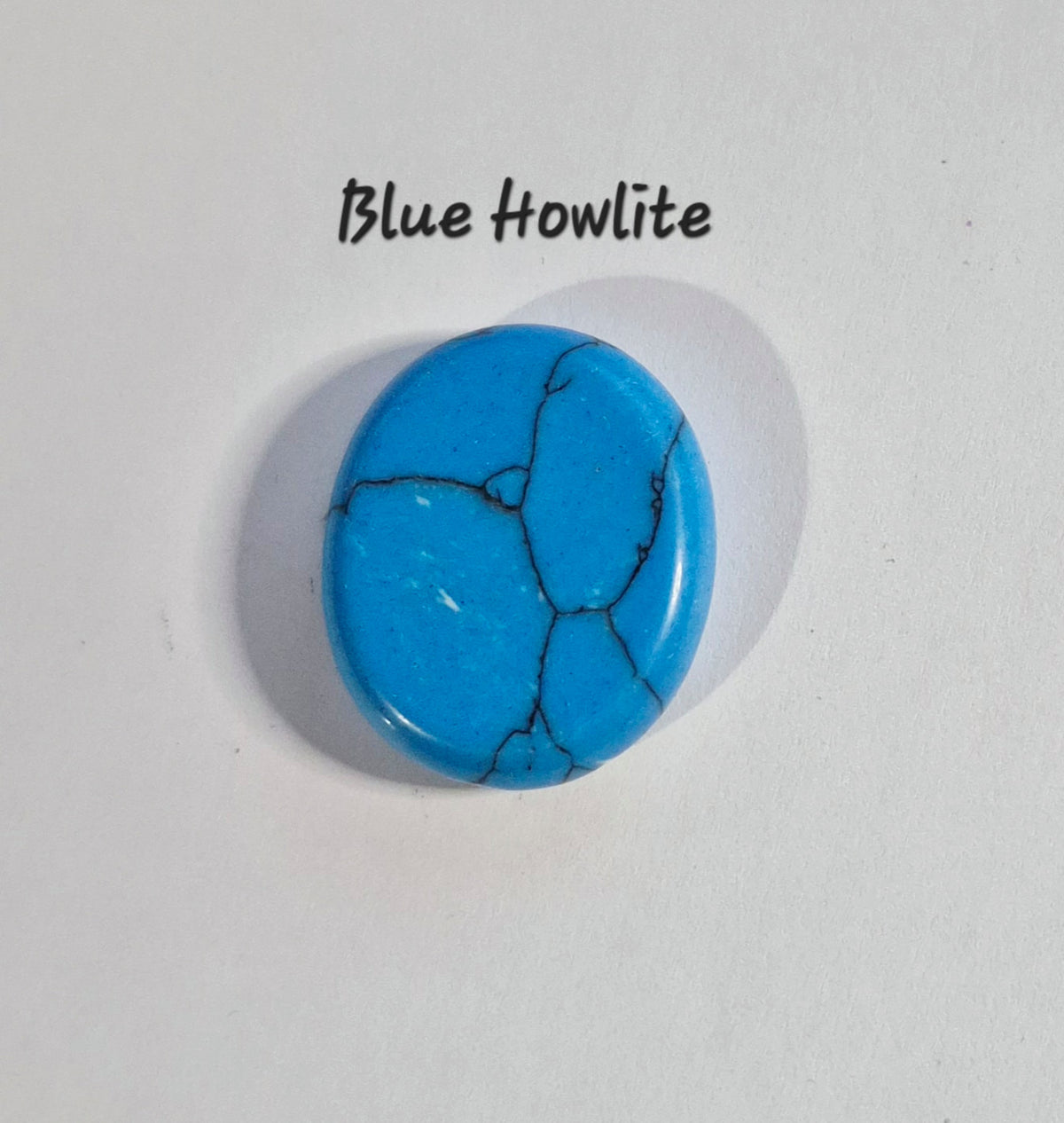 A single oval blue howlite worry stone with natural black veining, displayed on a white background with the text 'Blue Howlite' above it.