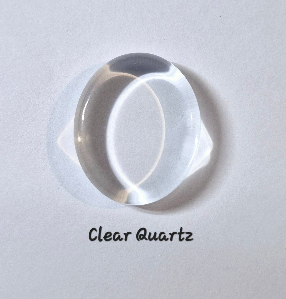 A clear oval quartz worry stone on a white background with the text 'Clear Quartz' underneath.