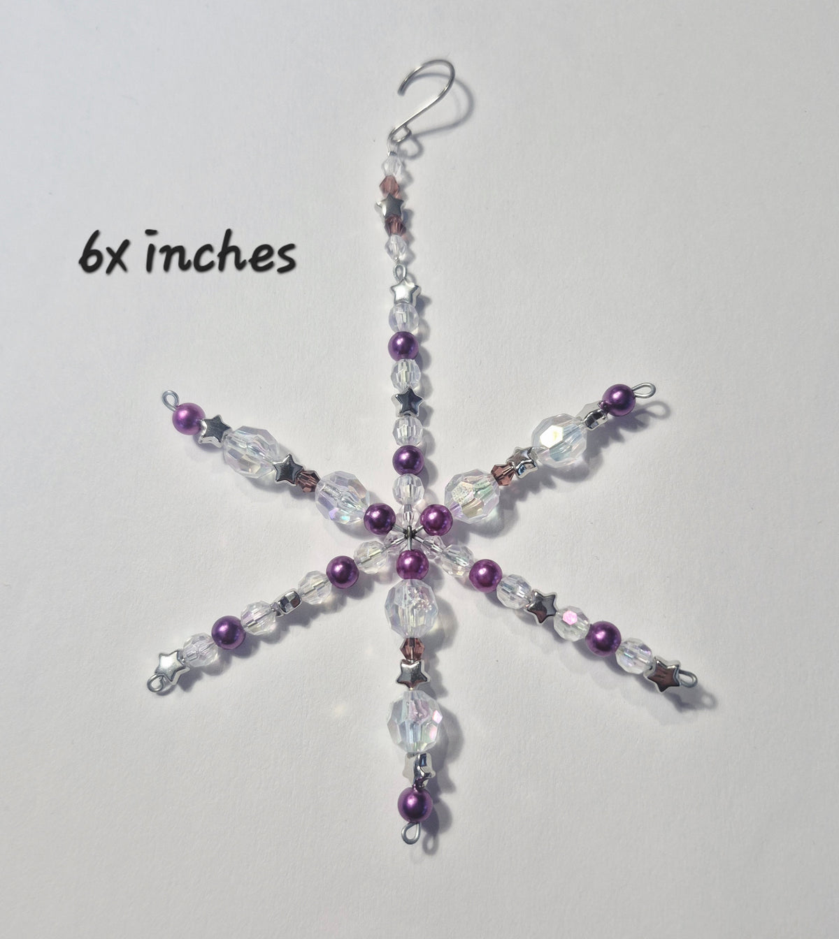 A beaded snowflake ornament with purple beads and clear faceted crystal beads, hanging from a silver fishhook. The text '6x inches' is printed on the left side of the image.