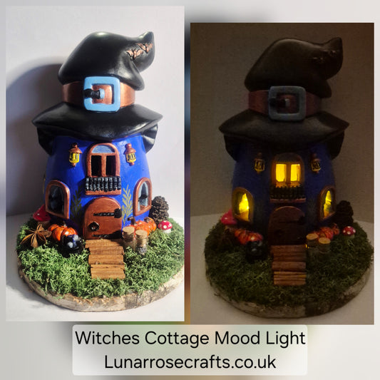 A split comparison of a handmade witch cottage figurine, shown unlit on the left and lit with warm yellow mood lights on the right. The cottage has a dark blue body, a black pointed witch hat with a blue buckle, a brown door, and is decorated with faux moss, pumpkins, and mushrooms on a round base.